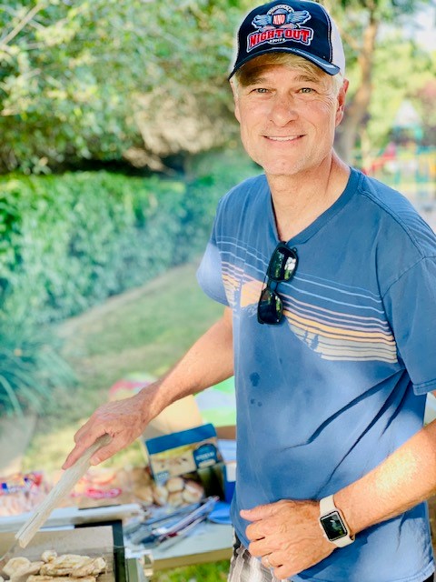 Man wearing National Night Out Cap barbequing at National Night Out event