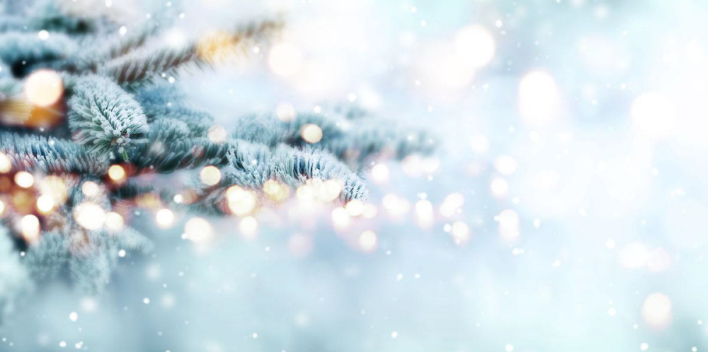 holiday image of a christmas tree with glittering lights and snow falling