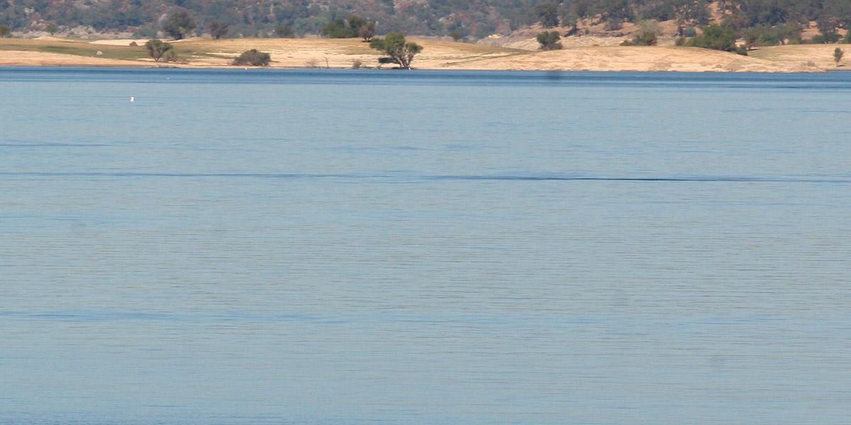 Folsom Lake water with hills and trees in the background