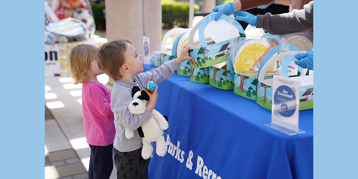 Spring Eggstravaganza two children picking up a free kit from Parks and Rec