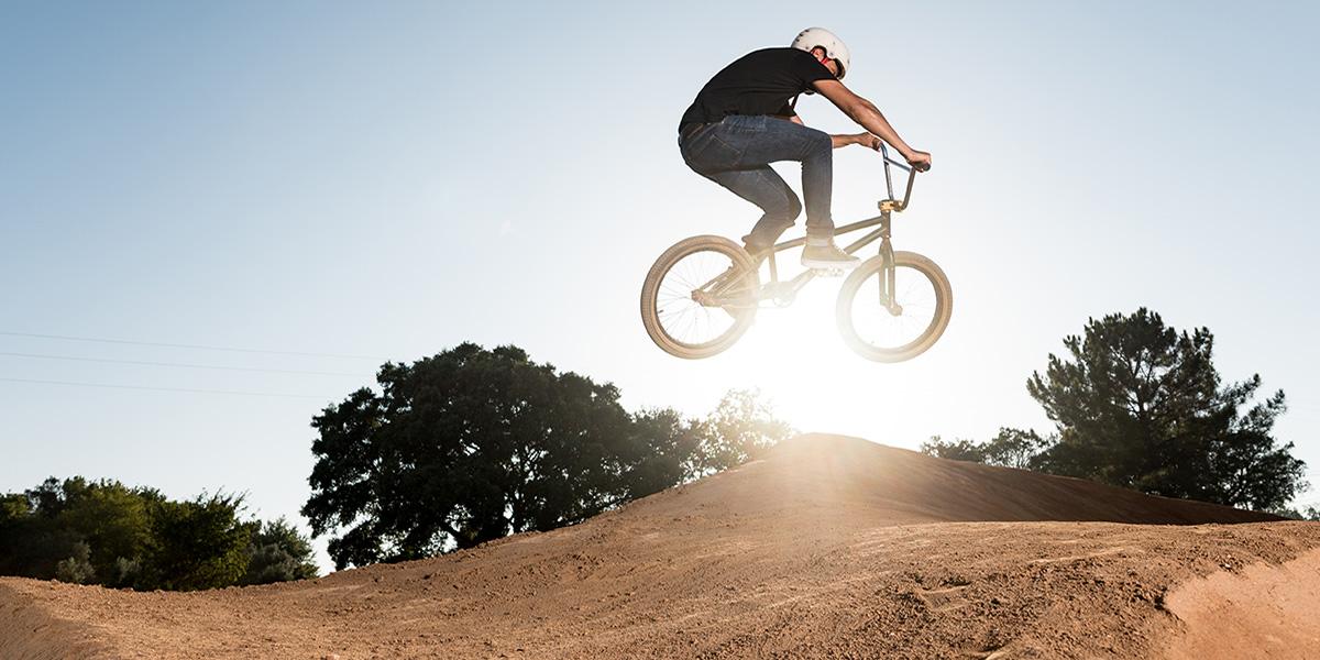 Bike jumping a dirt ramp at the bike park in Folsom