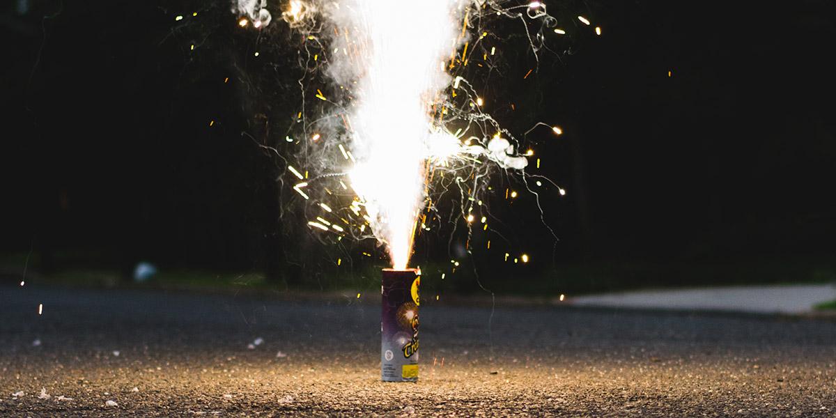 Lit safe and sane firework on ground