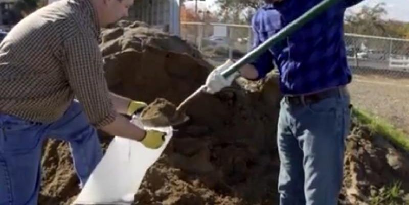 Two men filling sandbags