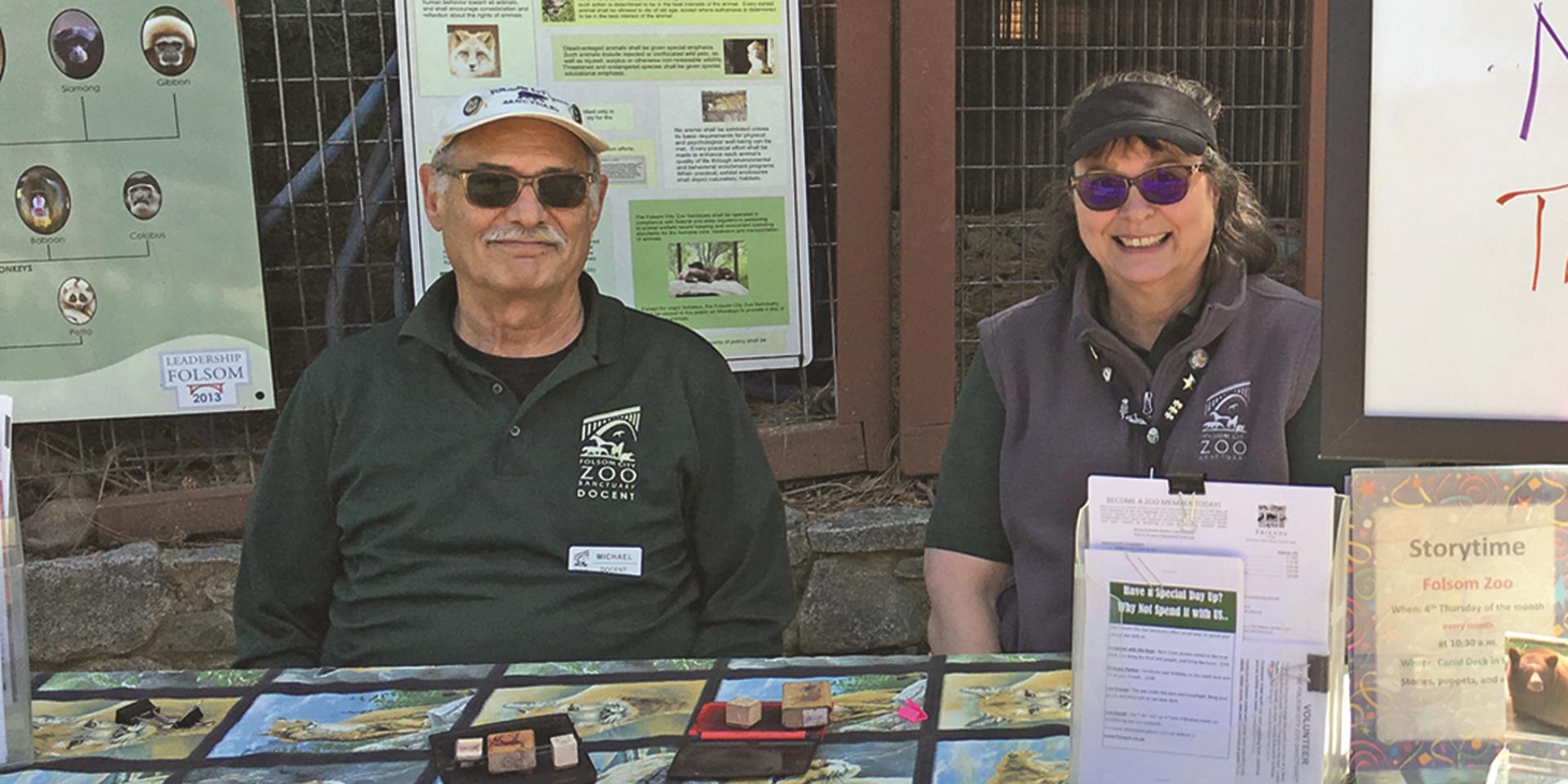 two zoo docents sitting at information table