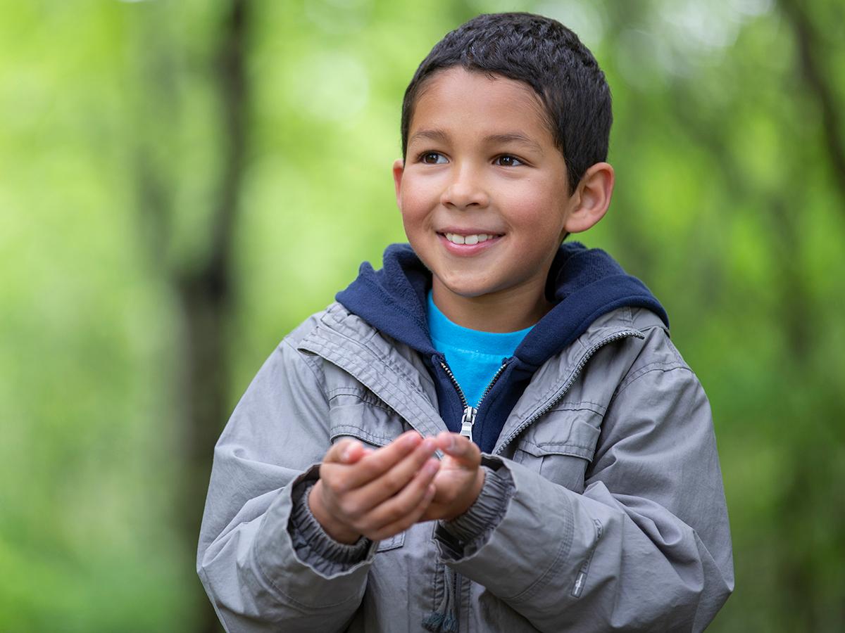 child in woods smiling