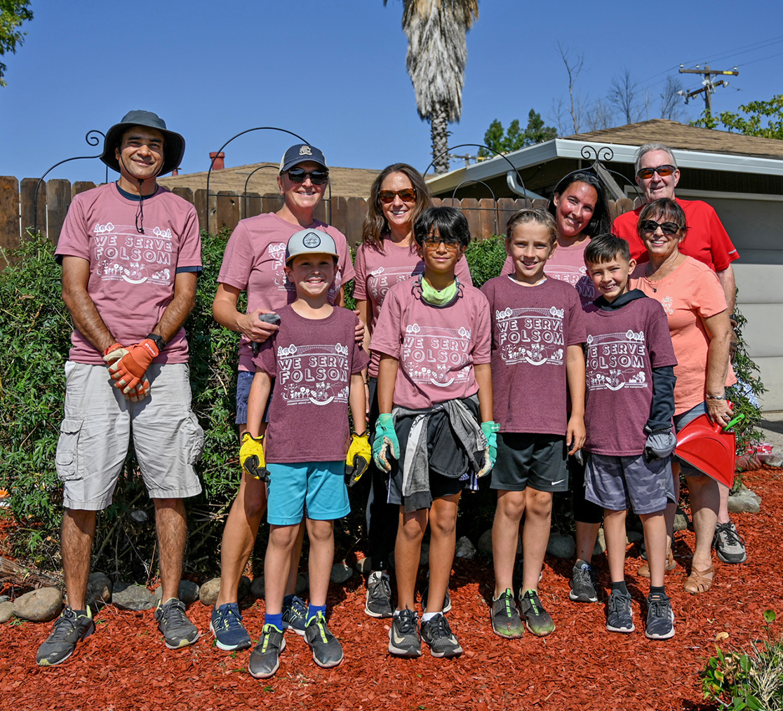 Group of Community Service Day youth and adult volunteers gathered outside a residential worksite